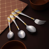 Gold-embellished cutlery pieces laid beside terracotta bowls and diamond-patterned placemat on deep brown table.